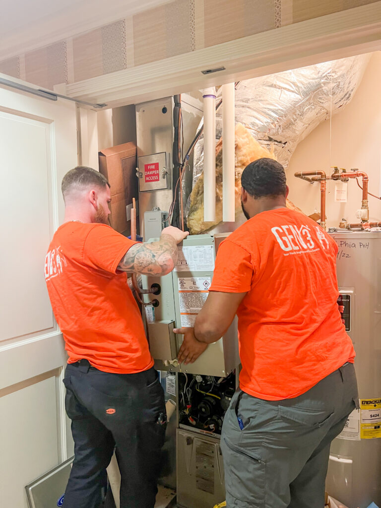 GEN3 Electric & HVAC technicians installing and securing a furnace inside a Philadelphia condo, ensuring safe and efficient HVAC system replacement.